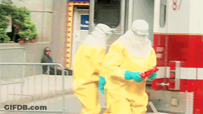 Two People In Yellow Suits Are Standing In Front Of An Ambulance With The Number 87 On The Side GIF