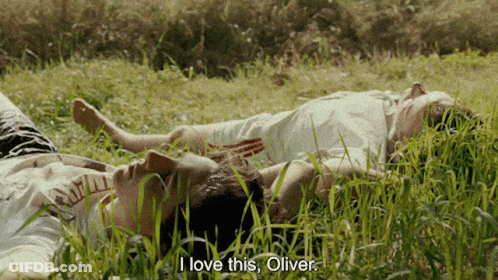 Two People Laying In The Grass With The Words " I Love This Oliver " On The Bottom GIF