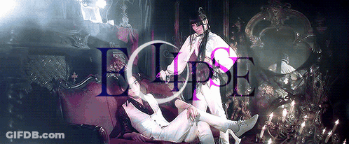 Two People Laying On A Red Couch With The Word Eclipse Written Above Them GIF