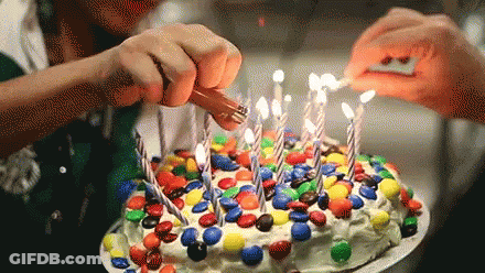 Two People Lighting Birthday Cake With M&Ms GIF