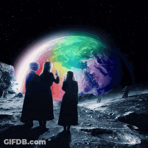 Two People Looking At A Rainbow Colored Planet GIF