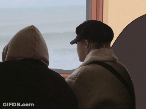 Two People Looking Out A Window With One Wearing A Hoodie GIF