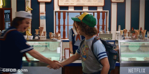 Two People Shake Hands In Front Of Netflix Advertisement GIF