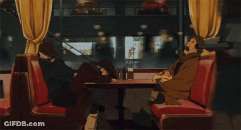 Two People Sit At A Table In A Diner With A Sign That Says Photo Shop In The Background GIF