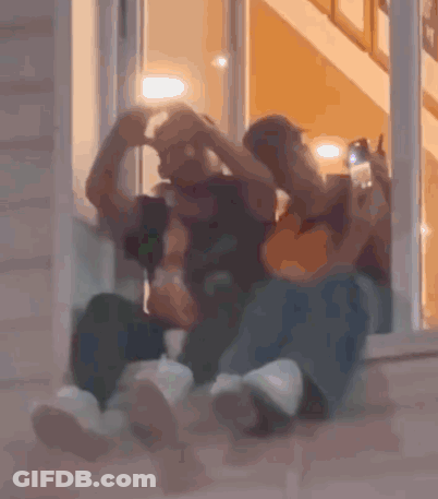 Two People Sitting In Front Of A Door GIF