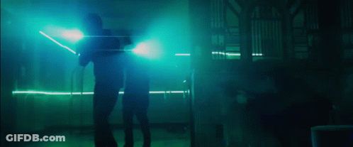 Two People Standing In A Dark Room With Blue Lights GIF