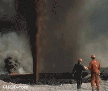 Two People Standing In Front Of A Large Flame GIF