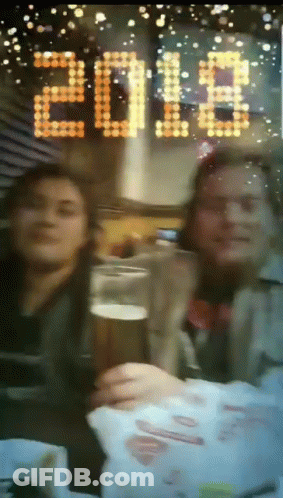 Two People Toasting With A Glass Of Beer In Front Of A Sign That Says 2018 GIF