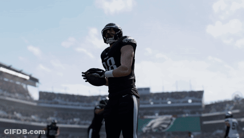 Two Philadelphia Eagles Players Are Standing On A Field GIF