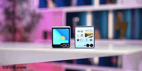 Two Phones On A Table One Of Which Says 19:10 On The Screen GIF