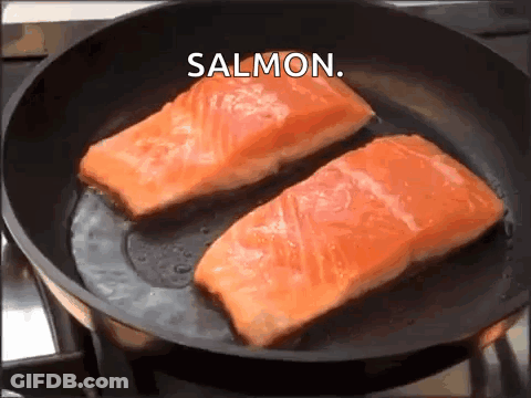 Two Pieces Of Salmon Are Being Cooked In A Frying Pan With The Word Salmon Above Them GIF