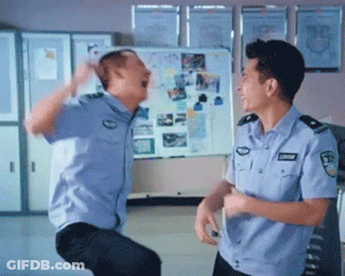 Two Police Officers Are Dancing In Front Of A White Board With Pictures GIF