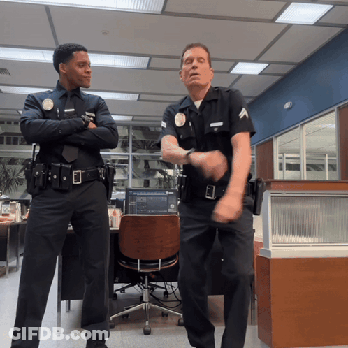 Two Police Officers Dancing In Office With L.A. Badge GIF