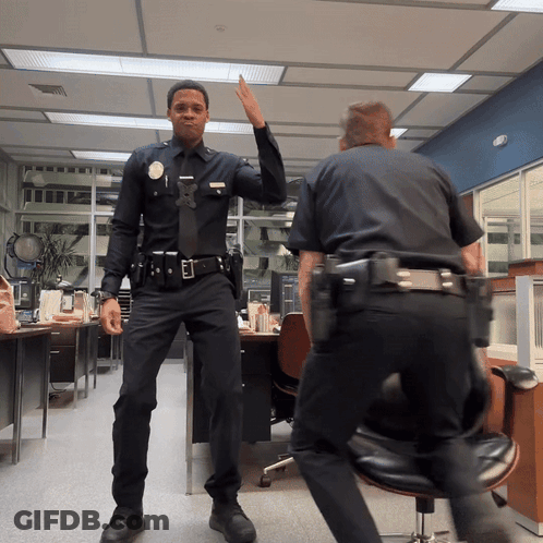 Two Police Officers High Fiving GIF