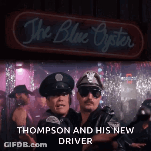 Two Police Officers Standing In Front Of The Blue Oyster GIF