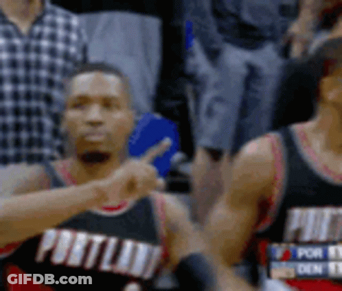 Two Portland Basketball Players Are Pointing At Each Other While Sitting On The Court . GIF
