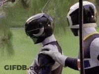 Two Power Rangers Are Standing Next To Each Other On A Field . GIF