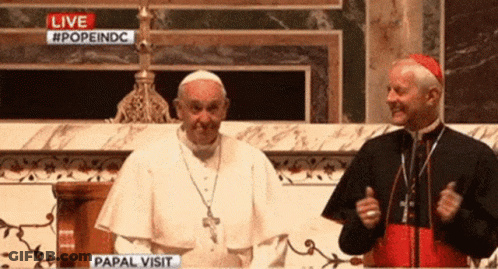 Two Priests Are Standing In Front Of A Live Papal Visit Screen GIF