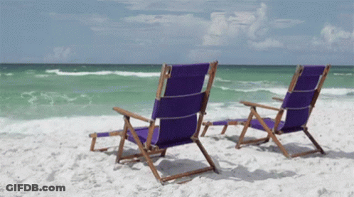 Two Purple Beach Chairs Sit On A Sandy Beach GIF
