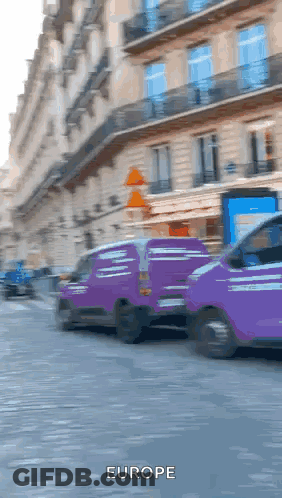 Two Purple Vans Are Driving Down A Street And The Word Europe Is On The Bottom Right GIF
