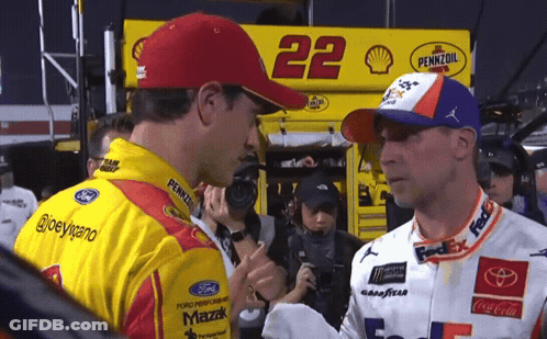 Two Race Car Drivers Are Shaking Hands In Front Of A Pennzoil Sign GIF