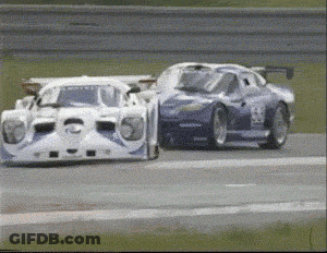 Two Race Cars Are Racing On A Track And One Has The Number 26 On The Side GIF