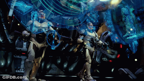 Two Robots Are Standing In Front Of A Machine With The Number 05 On It GIF