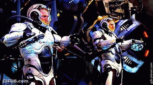 Two Robots Are Standing Next To Each Other With The Number 05 On The Bottom Left GIF