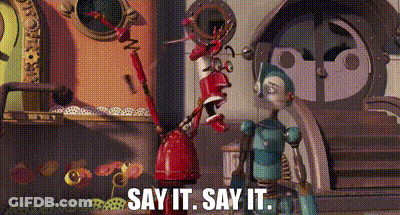 Two Robots In Front Of Say It Building GIF