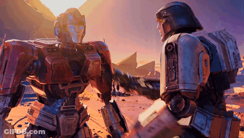 Two Robots Shaking Hands In Desert Landscape GIF