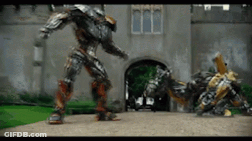 Two Robots Standing In Front Of Building GIF
