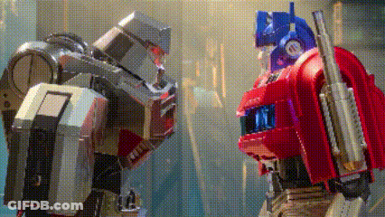 Two Robots Standing Next To Each Other One Is A Transformer GIF