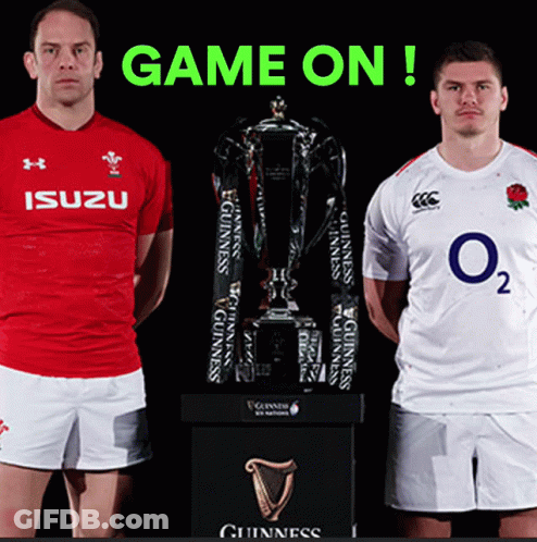 Two Rugby Players Are Standing Next To A Trophy With The Words Game On Behind Them GIF
