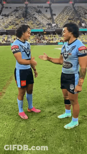 Two Rugby Players On A Field With One Wearing A Shirt That Says New GIF