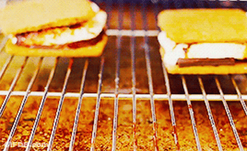 Two S'mores Are Being Cooked On A Grill .. GIF