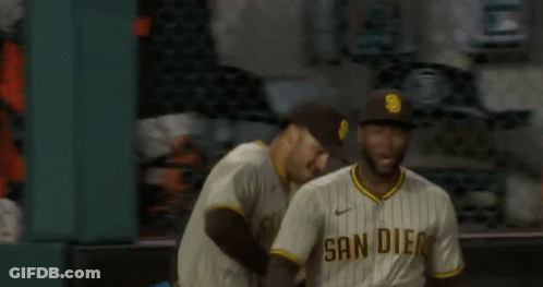 Two San Diego Padres Baseball Players Are Standing On The Field . GIF