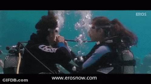 Two Scuba Divers Are Looking At Each Other In The Water And The Website Erosnow.com Is Visible In The Corner GIF