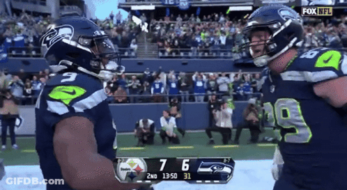 Two Seahawks Players Celebrate A Touchdown During A Game GIF