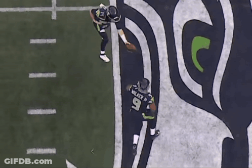 Two Seahawks Players Walking On The Field With The Number 9 On Their Jersey GIF