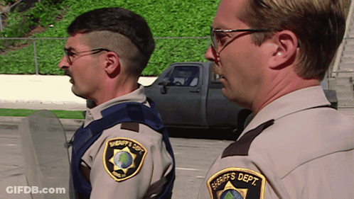 Two Sheriff 'S Deputies Are Standing Next To Each Other In A Parking Lot GIF