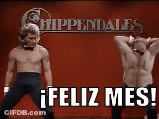 Two Shirtless Men Are Dancing On A Stage In Front Of A Sign That Says Feliz Mes ! GIF