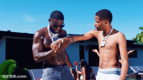 Two Shirtless Men Are Standing Next To Each Other And One Of Them Has A Tattoo On His Arm GIF