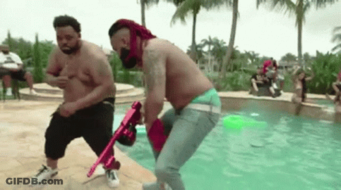 Two Shirtless Men Holding Pink Gun In Pool GIF
