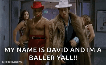 Two Shirtless Men One In Red Hat And Fur Coat GIF