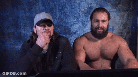 Two Shirtless Men Sitting Next To Computer Screen GIF