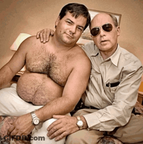 Two Shirtless Men Sitting On Bed GIF