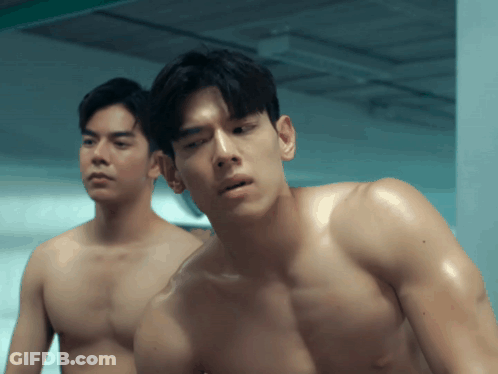 Two Shirtless Men Standing In Dark Room GIF