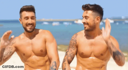 Two Shirtless Men Waving On Beach GIF