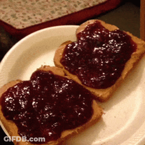 Two Slices Of Peanut Butter And Jelly Toast On A White Plate GIF