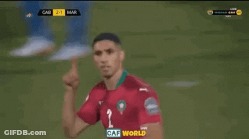 Two Soccer Players Are Celebrating A Goal In Front Of A Large Screen That Says Caf World On It GIF